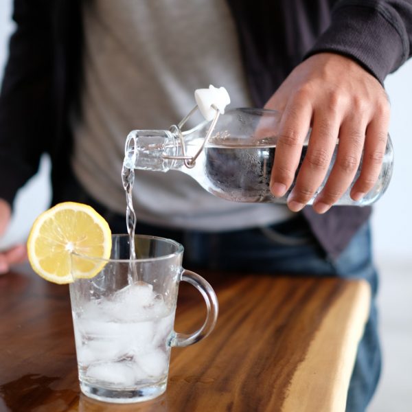 Eau versée dans un verre avec de la glace et citron Maple 3